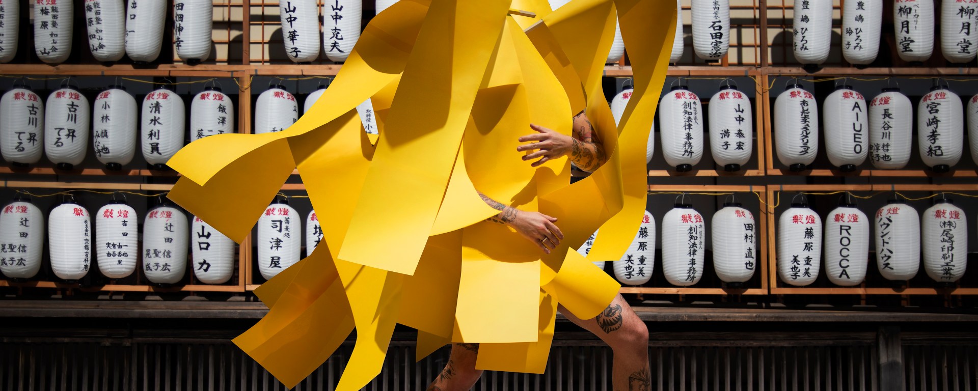 Image of artist Gerwyn Davies in yellow with japanese lantern