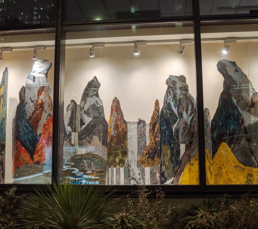 A glass shop front with mountainous diorama as an art installation